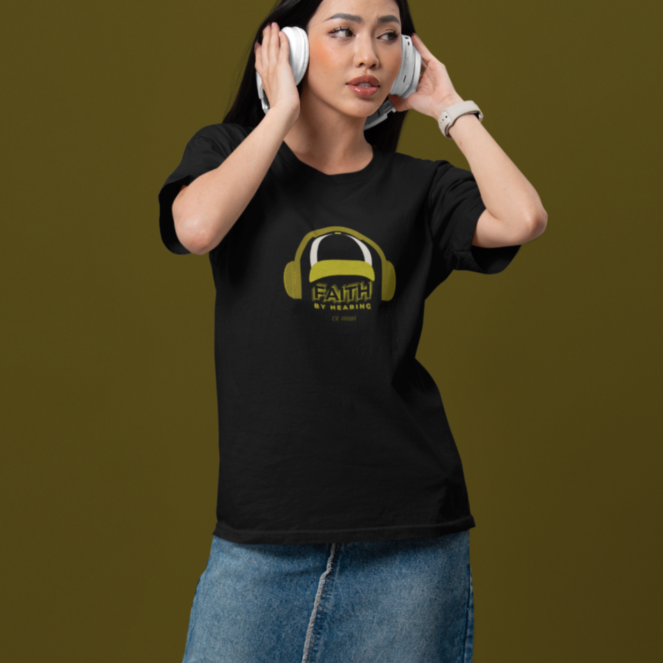 Young woman wearing black faith by hearing t-shirt with gold headphone logo relaxed fit Printify tee
